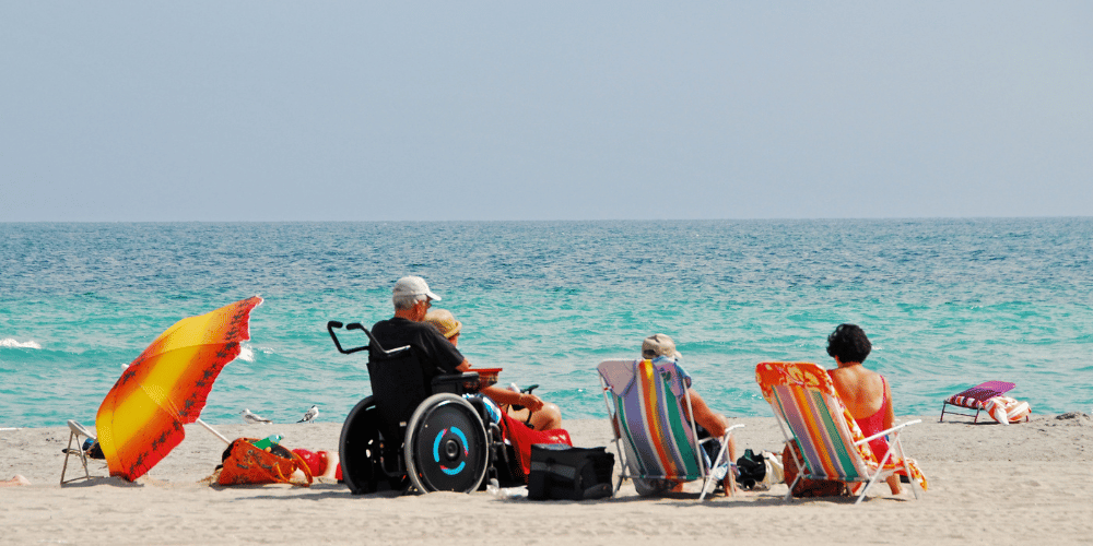 Personne en situation d'handicap à la plage avec ces proches