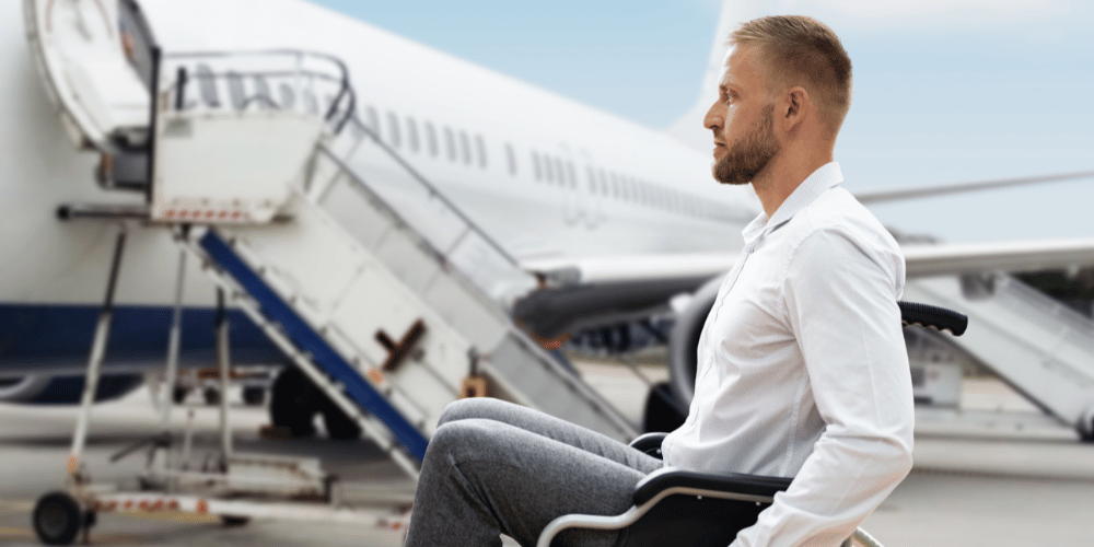 Personne en fauteuil roulant qui se dirige vers un avion.